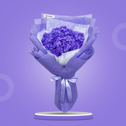 Kunzite Timeless dried bouquet with purple hydrangea in purple tissue and white non-woven wrap with light purple ribbon