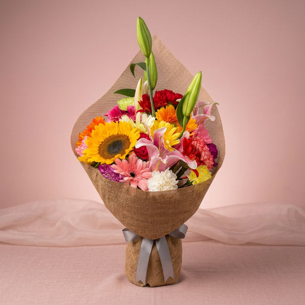 Lavish Love Flower Bouquet with assorted carnations, gerberas, sunflower, and stargazer lily in Chinese burlap wrap for flower delivery in Metro Manila