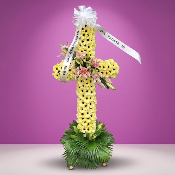 Life Memory Cross Stand with yellow gerbera daisies, stargazer lilies, and anahaw leaves