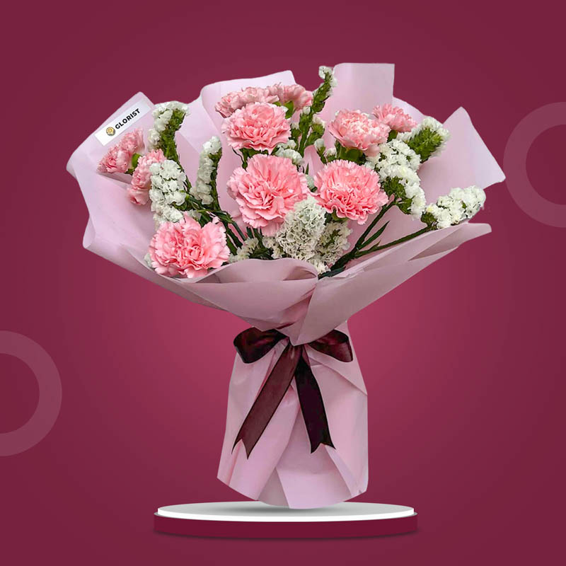 Mellow Radiance bouquet with 10 light pink carnations and white statice in light pink Korean wrap with brown ribbon