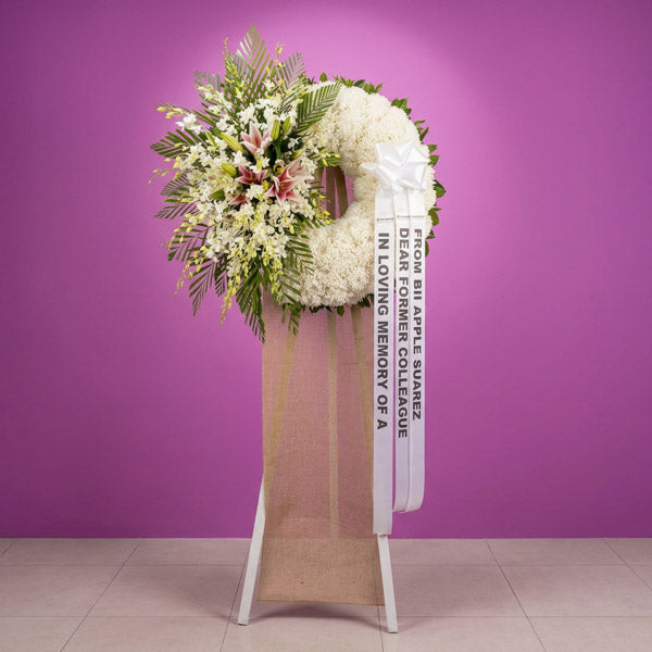 Orchid and white stargazer funeral flower stand arrangement