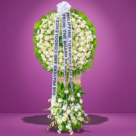 Peaceful Memory Wreath Stand with white chrysanthemums, white orchids, and anahaw leaves