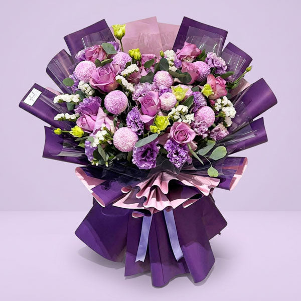 Purple China roses with lisianthus, pompom chrysanthemums, and eucalyptus wrapped in violet Korean paper, a luxury anniversary bouquet with same-day Manila delivery
