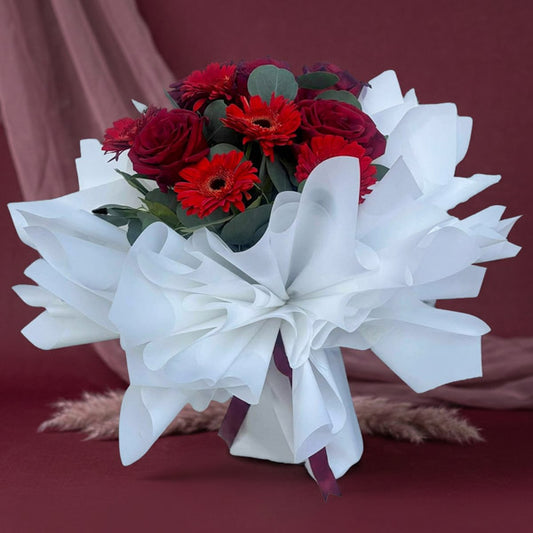 Red Ecuadorian roses and gerbera bouquet with eucalyptus fillers and white wrapping