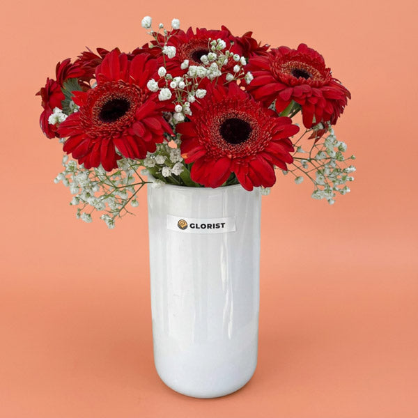 Red gerbera daisies with gypsophila baby's breath in a glass vase, a cheerful get-well and birthday flower gift with same-day Metro Manila delivery