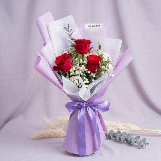 Red China rose bouquet with gypsophila and eucalyptus in light purple wrapping