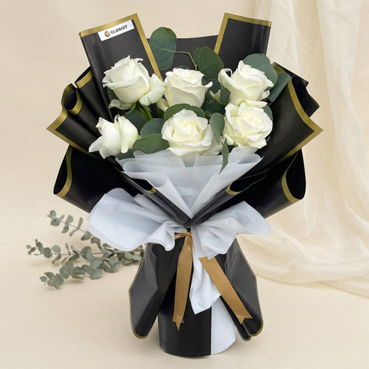 Savvy Flora bouquet with 6 white China roses and eucalyptus silver dollar in black‑bordered and white Korean wrap with light gold ribbon