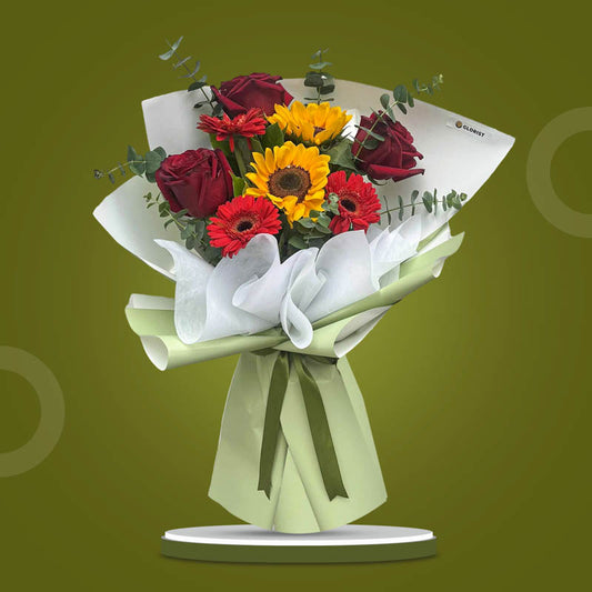 Sincere Love bouquet with red Ecuadorian roses, sunflowers, gerberas, and eucalyptus in matcha and white wrap with dark olive ribbon