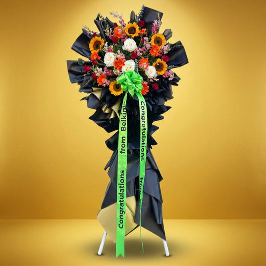 Successful Launch Inaugural Stand with sunflowers, orange gerbera daisies, red roses, white Ecuadorian roses, and eucalyptus fillers