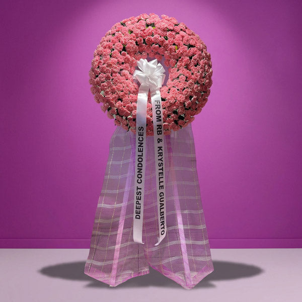 Light pink carnation funeral flower stand with rosal greenery