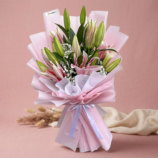 Unfazed Breeze bouquet with 5 stem Stargazer lilies and gypsophila in light pink and white wrap with white ribbon