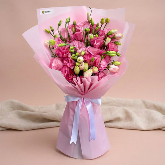 Velvet Fields bouquet with light pink lisianthus paper roses wrapped in pink Korean paper and tied with a white ribbon