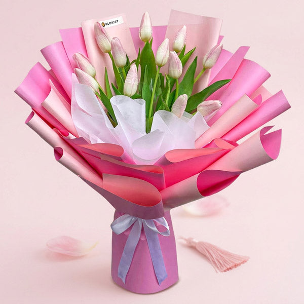 Versatile Perennial bouquet with twelve light pink tulips in two-toned pink Korean wrap tied with a white ribbon