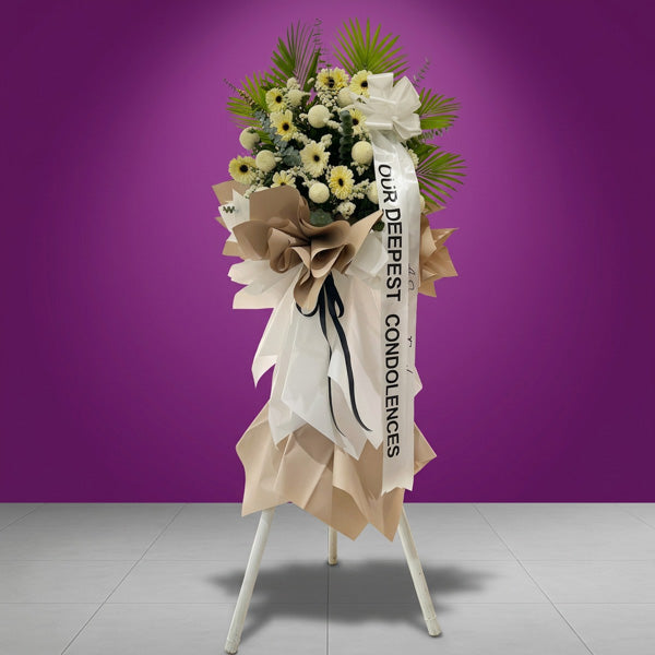 White pompoms and gerbera funeral stand with Korean wrapping and black ribbon