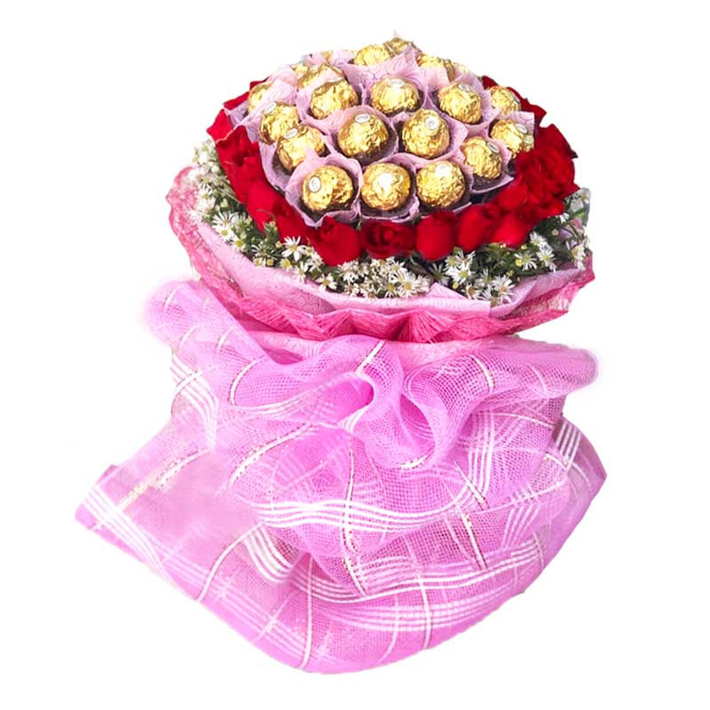 Impressive bouquet of 2 dozen red roses with Aster fillers, wrapped in tissue and Abaca, adorned with net, accompanied by Ferrero Rocher chocolates.