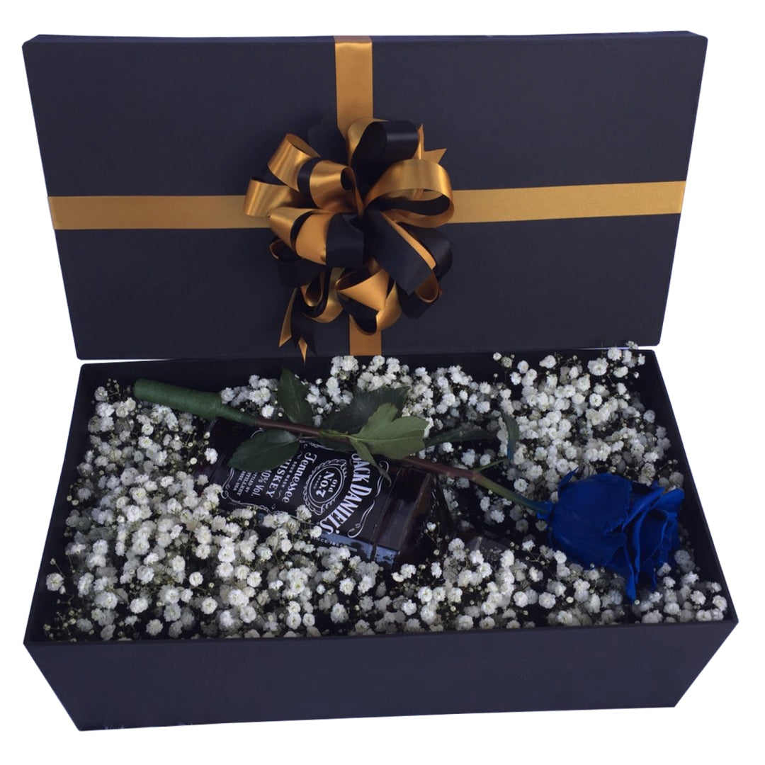 Enchanting blue rose floral box with delicate gypsophila accents and a touch of elegance from a whiskey bottle satin ribbon.